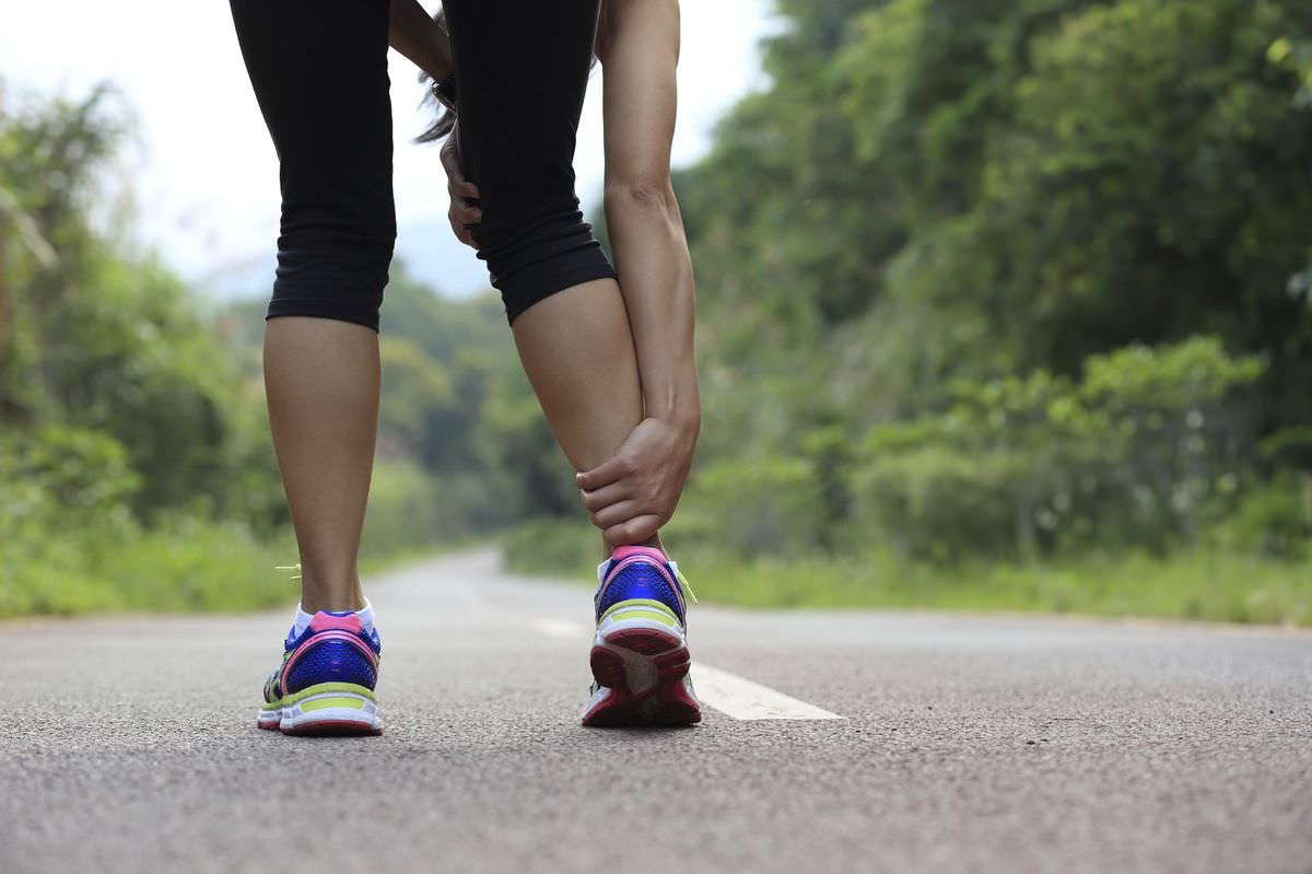 woman runner hold her sports injured leg