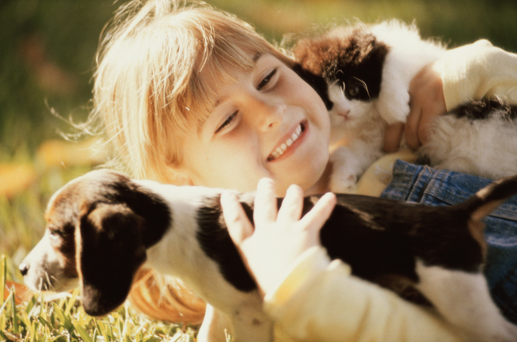 Close-up of a girl holding a puppy and a kitten