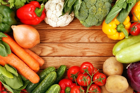 Vegetables on wood background with space for text.