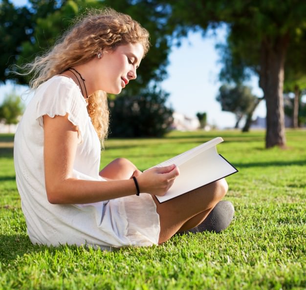 side-view-of-calm-woman-reading-in-the-park_1149-987