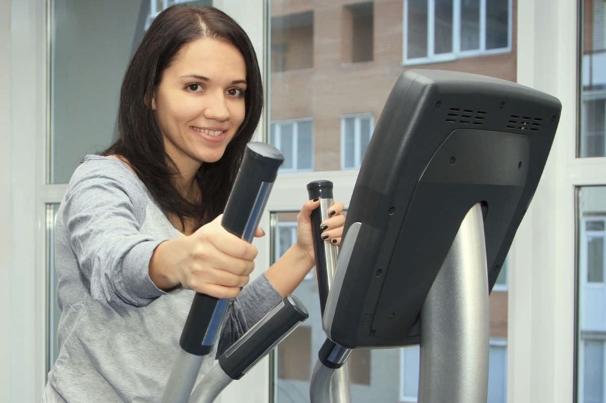 young woman doing exercise on a elliptical trainer