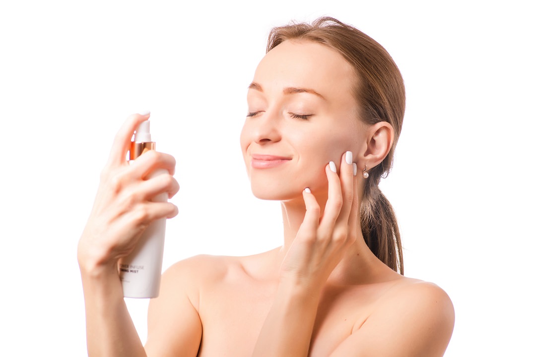 Beautiful woman face spray on face lotion cosmetology