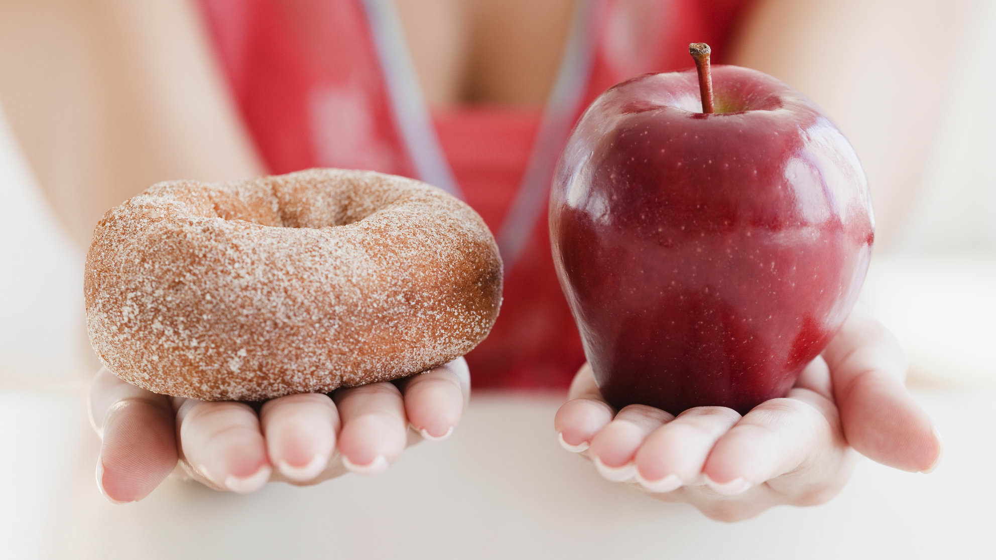 USA, New Jersey, Jersey City, Close up of woman's hands holding donut and apple