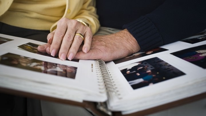 Mid section view of a couple looking at a photo album