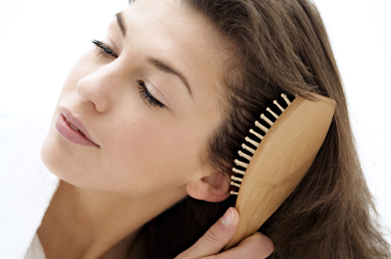 Portrait of a young woman brushing her hair